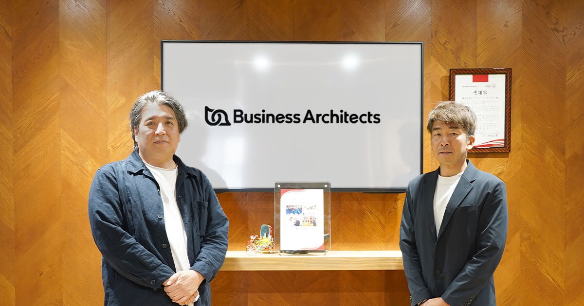 写真：BAオフィスエントランスにて、ねぎお社長と小山の集合写真