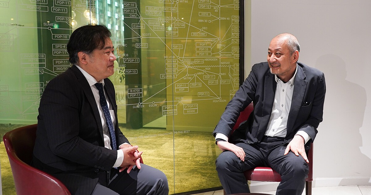 写真：株式会社ジーニー平井氏が話し、株式会社ビジネス・アーキテクツ浦が聞く様子