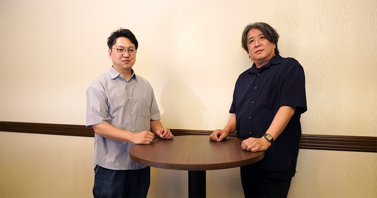 集合写真：プロジェクトマネージャー・シニアディレクター　野島（右）、事業部長　小山（左）